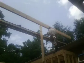 Carpenter setting a ridge beam over a new addition frame — Ice Dam Removal by Roofing Brothers in Perris