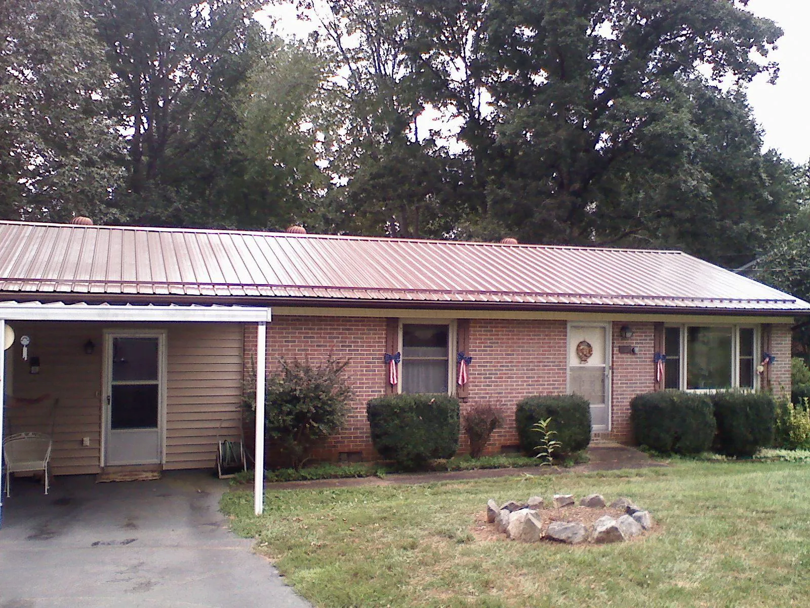 Bronze metal roof and carport on a brick ranch home — Roof Repair work by our crew in Perris